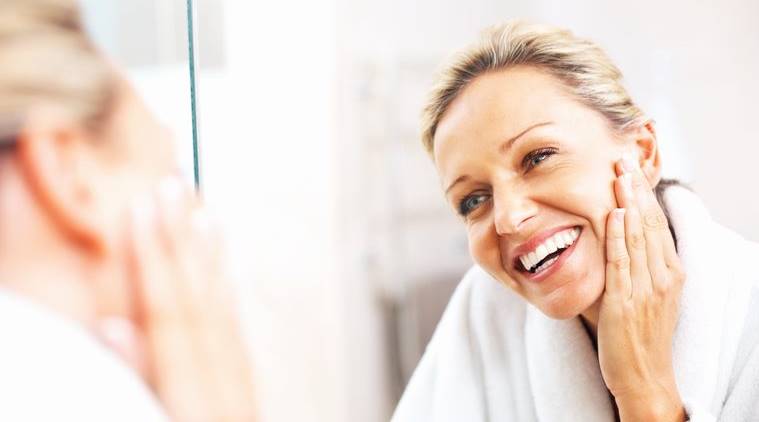 Happy mature woman admiring herself in the mirror